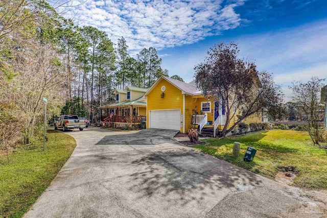 view of front of home with a garage, covered porch, and a front lawn