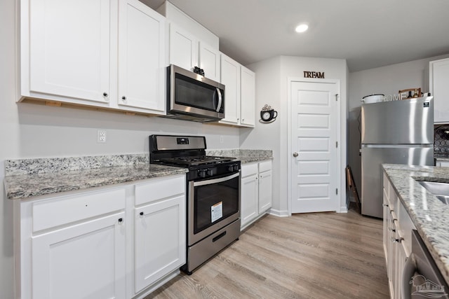 4616 Honor Guard Way, Crestview, FL 32539 - kitchen featuring appliances with stainless steel finishes, white cabinetry, light wood-type flooring, light stone counters, and recessed lighting