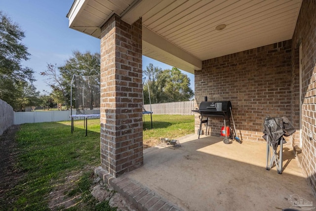 4616 Honor Guard Way, Crestview, FL 32539 - fenced backyard featuring a trampoline, a grill, and a patio area