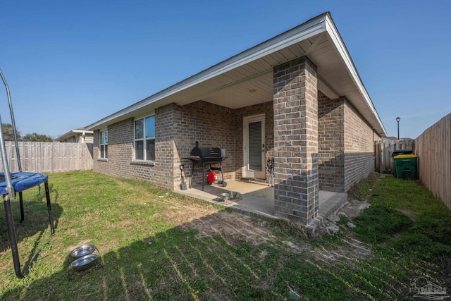 4616 Honor Guard Way, Crestview, FL 32539 - rear view of property featuring brick siding, a patio, and a fenced backyard