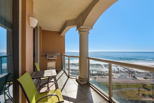 balcony featuring a water view and a beach view