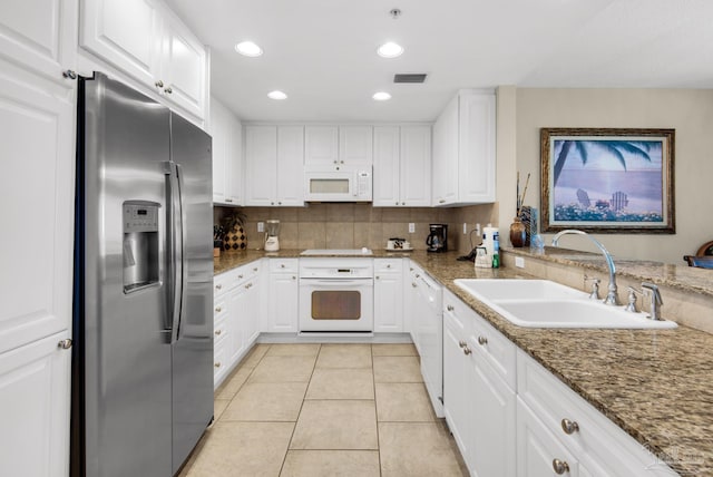 kitchen featuring decorative backsplash, white appliances, sink, stone countertops, and white cabinets