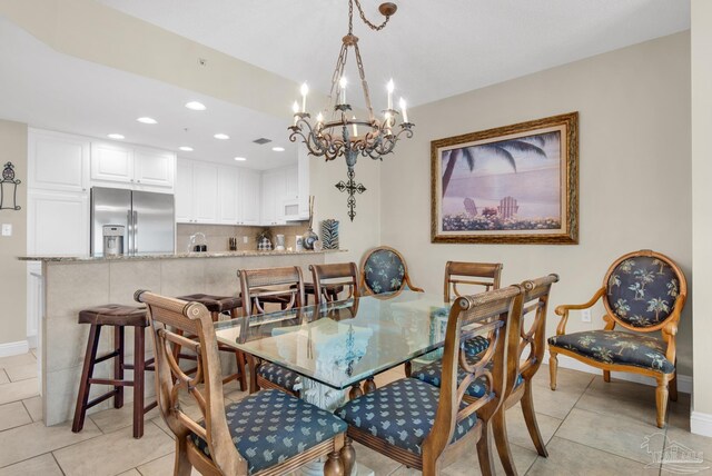 dining space featuring light tile patterned floors and a chandelier