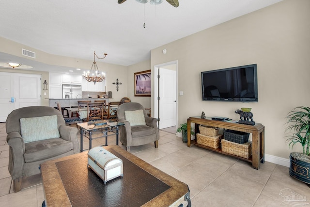 living room featuring light tile patterned floors and ceiling fan with notable chandelier