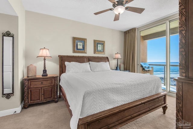 bedroom with access to outside, a water view, multiple windows, and ceiling fan