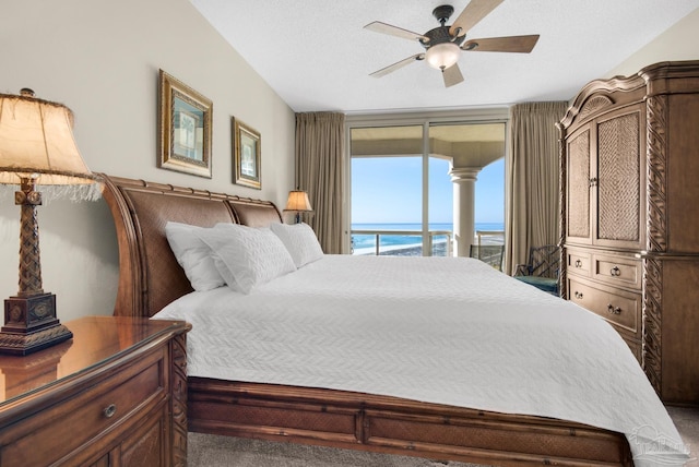 bedroom featuring access to outside, carpet floors, ceiling fan, and a water view