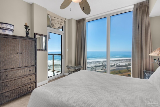 bedroom with ceiling fan, a water view, and a view of the beach