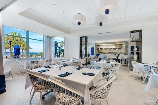 dining area with a raised ceiling and light hardwood / wood-style flooring