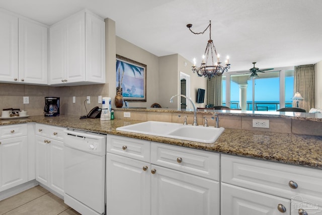 kitchen featuring ceiling fan with notable chandelier, white dishwasher, sink, white cabinets, and hanging light fixtures