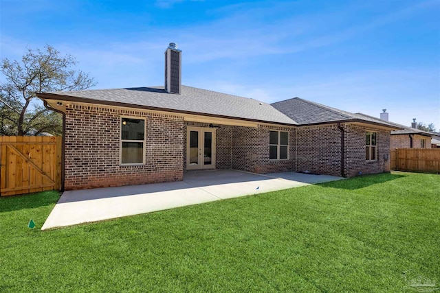 back of house with french doors, a chimney, a patio area, and brick siding