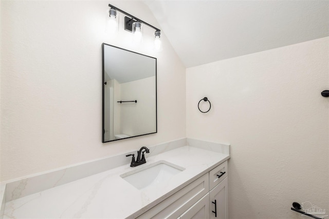 bathroom featuring vaulted ceiling and vanity