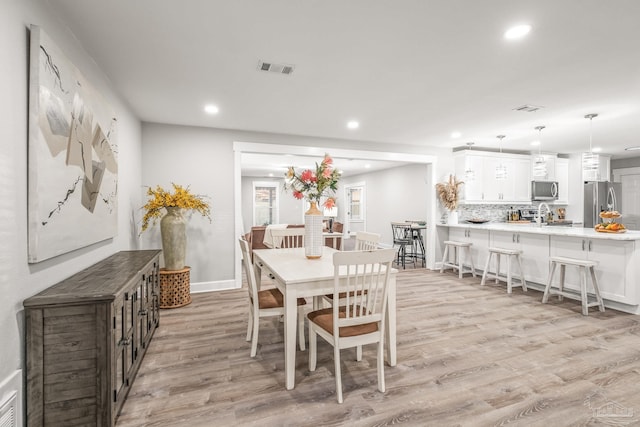 dining room with light wood-type flooring and sink