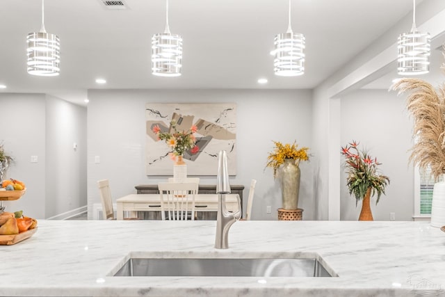 kitchen with pendant lighting, sink, and a chandelier