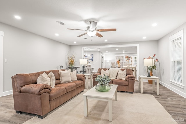 living room featuring ceiling fan and light hardwood / wood-style flooring