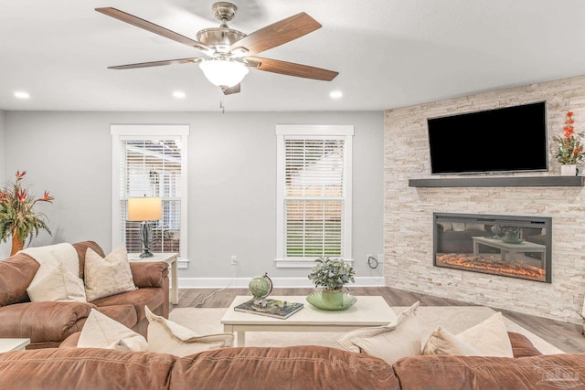 living room featuring a fireplace, hardwood / wood-style floors, and ceiling fan