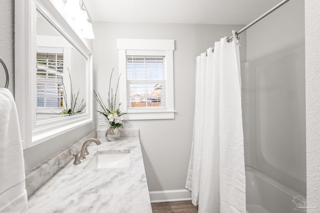 bathroom with hardwood / wood-style flooring, vanity, and shower / tub combo