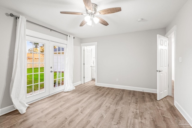 empty room with ceiling fan, light hardwood / wood-style flooring, and french doors