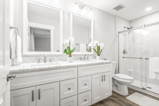 bathroom featuring hardwood / wood-style flooring, vanity, toilet, and walk in shower