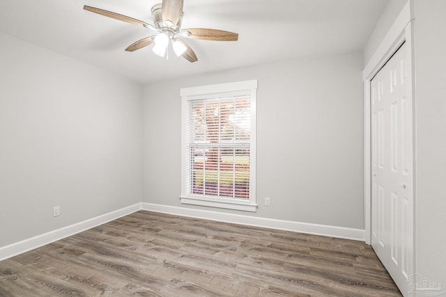 unfurnished bedroom with wood-type flooring, a closet, and ceiling fan