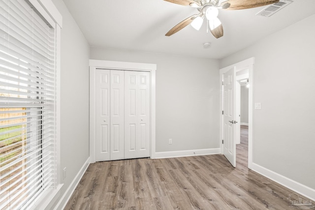 unfurnished bedroom with ceiling fan, light hardwood / wood-style floors, and a closet