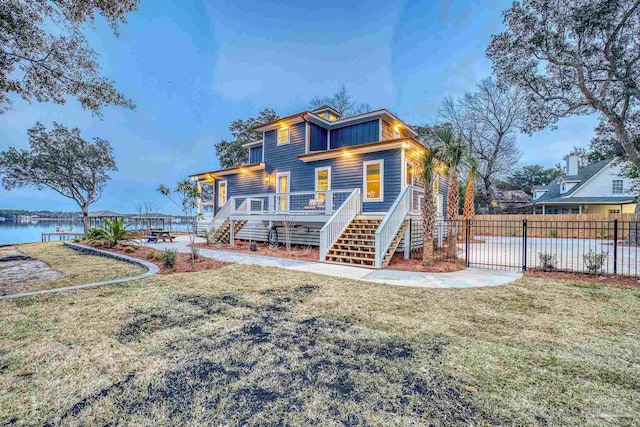 back of property featuring a lawn, a porch, and a water view