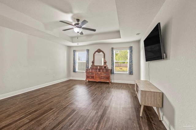 4036 Millwright Way, Pace, FL 32571 - living room with dark wood-style flooring, a textured ceiling, a ceiling fan, baseboards, and a tray ceiling