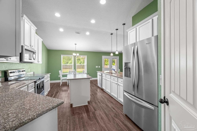 kitchen with a sink, a textured ceiling, stainless steel appliances, white cabinetry, and dark wood-style floors