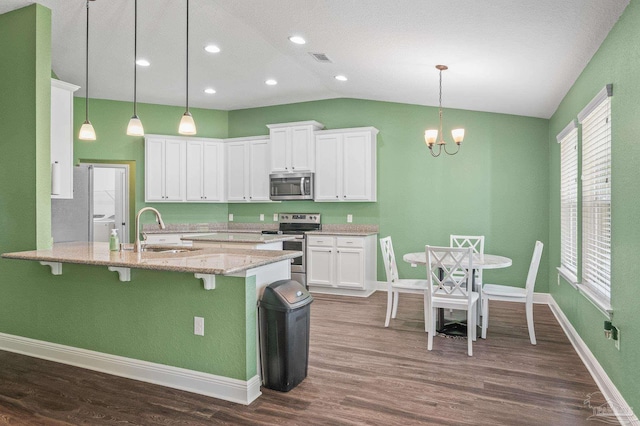 kitchen with a sink, white cabinetry, a peninsula, and stainless steel appliances