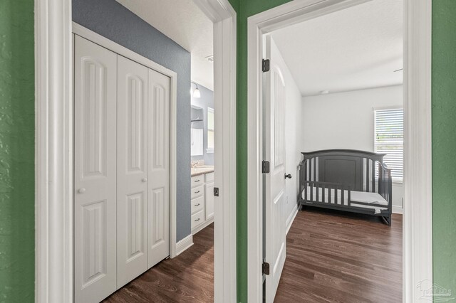 bedroom with baseboards, dark wood finished floors, multiple windows, and a closet