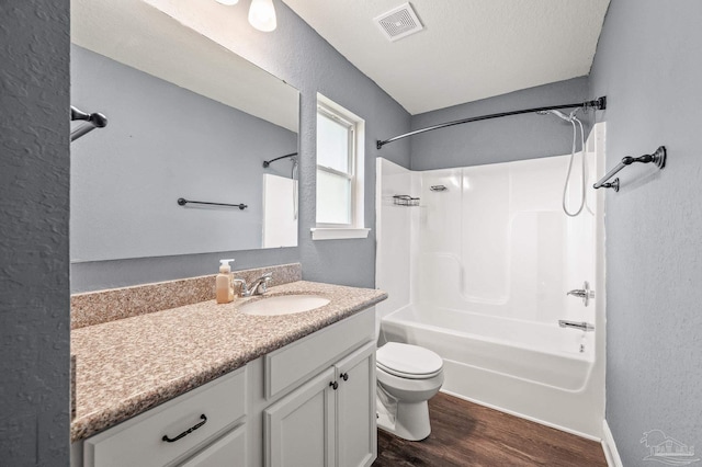 bathroom with vanity, toilet, bathing tub / shower combination, wood finished floors, and visible vents