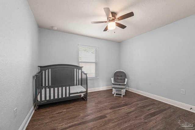 bedroom featuring baseboards, ceiling fan, a textured ceiling, and wood finished floors