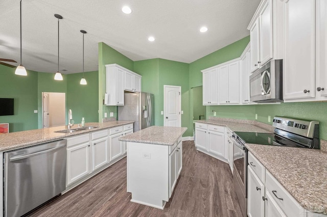 kitchen with a kitchen island, dark wood-style floors, white cabinetry, a sink, and stainless steel appliances