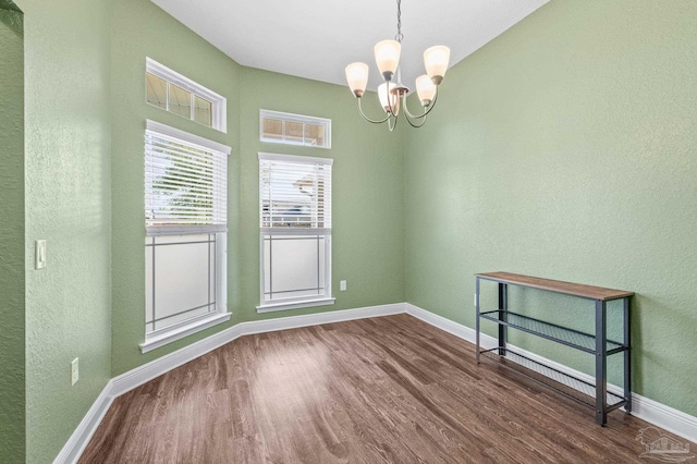 4036 Millwright Way, Pace, FL 32571 - empty room featuring an inviting chandelier, dark wood finished floors, a textured wall, and baseboards
