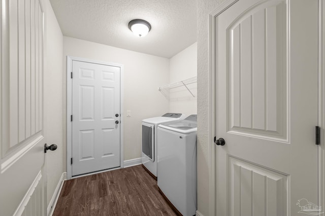 laundry room featuring laundry area, baseboards, dark wood-style floors, a textured ceiling, and separate washer and dryer