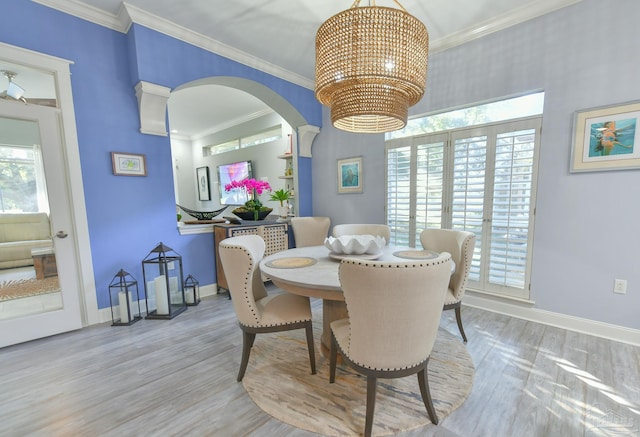 dining room with ornamental molding, light hardwood / wood-style flooring, and a chandelier