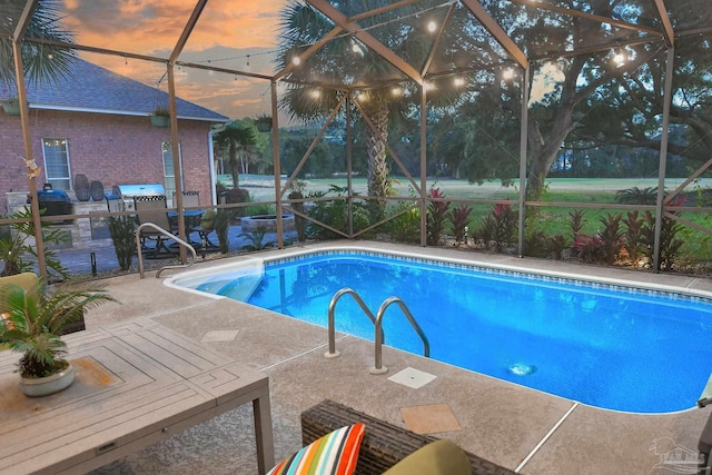 pool at dusk featuring glass enclosure and a patio area