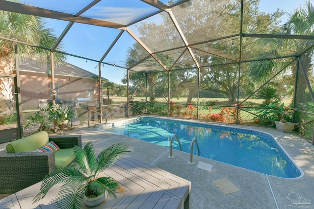 view of pool with glass enclosure and a patio area