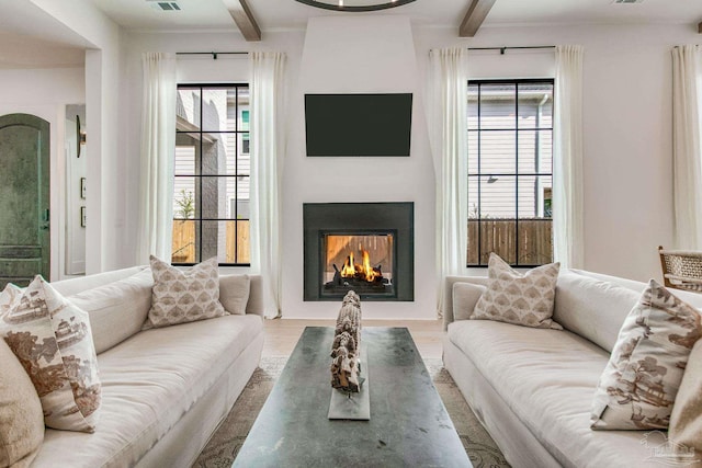 living room with a fireplace, wood-type flooring, and beam ceiling