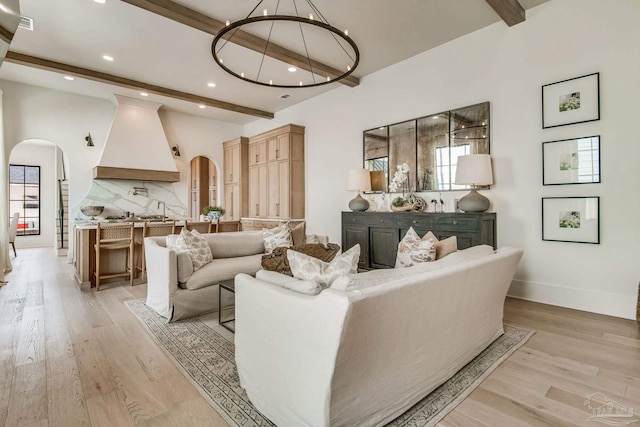 living room with light hardwood / wood-style flooring and beamed ceiling