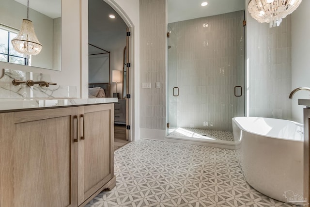 bathroom featuring vanity, shower with separate bathtub, tile patterned flooring, and a notable chandelier