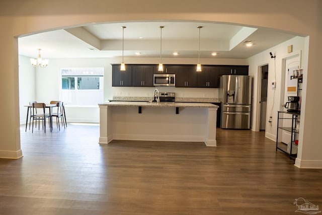 1758 Tate Rd, Cantonment, FL 32533 - kitchen with appliances with stainless steel finishes, a tray ceiling, a kitchen breakfast bar, a kitchen island with sink, and recessed lighting