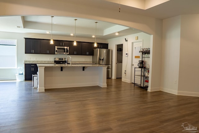 1758 Tate Rd, Cantonment, FL 32533 - kitchen featuring stainless steel appliances, a tray ceiling, a breakfast bar area, arched walkways, and recessed lighting