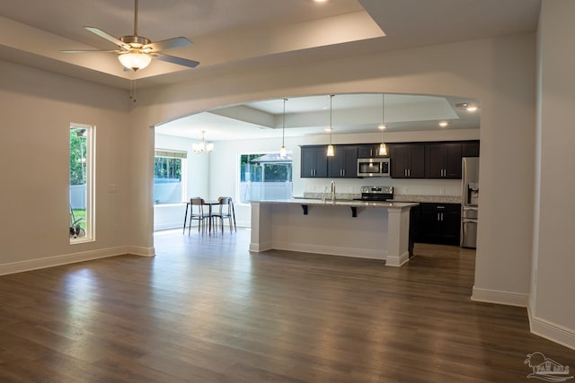 1758 Tate Rd, Cantonment, FL 32533 - kitchen with a raised ceiling, appliances with stainless steel finishes, a breakfast bar, dark wood-style flooring, and recessed lighting