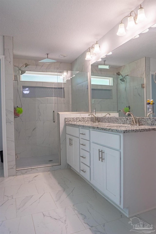 1758 Tate Rd, Cantonment, FL 32533 - bathroom featuring marble look tiles, a marble finish shower, vanity, and a textured ceiling