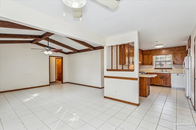 kitchen with sink, white appliances, light tile patterned floors, ceiling fan, and vaulted ceiling with beams