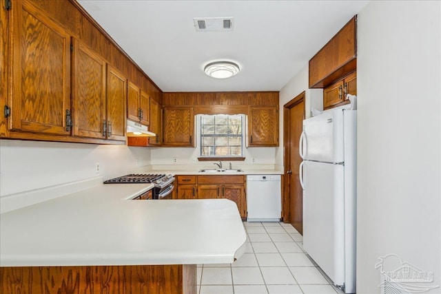 kitchen with sink, white appliances, kitchen peninsula, and light tile patterned floors