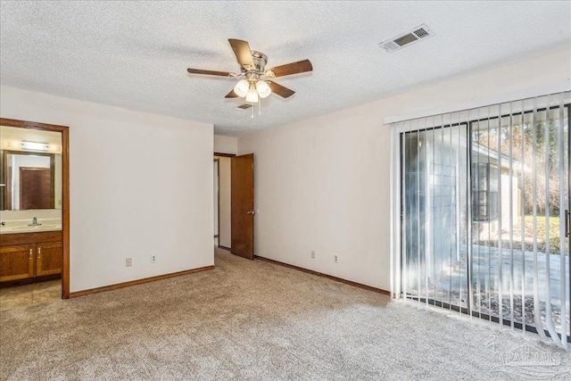 carpeted empty room featuring sink, a textured ceiling, and ceiling fan