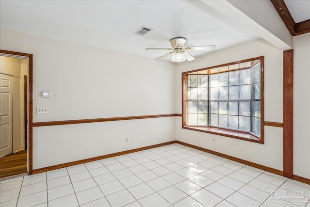 tiled spare room with beamed ceiling and ceiling fan