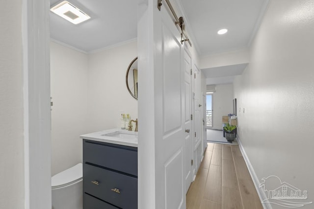 bathroom with toilet, vanity, and crown molding