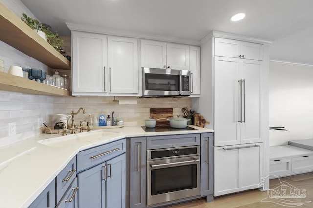 kitchen featuring white cabinets, appliances with stainless steel finishes, sink, and tasteful backsplash